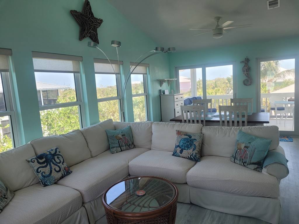 Living room with a large sectional sofa in blue-toned pillows and a coral accent