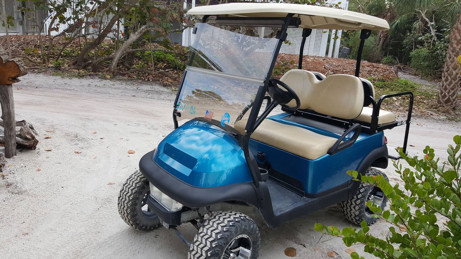 The four-seat golf cart included with the rental, parked in the sand